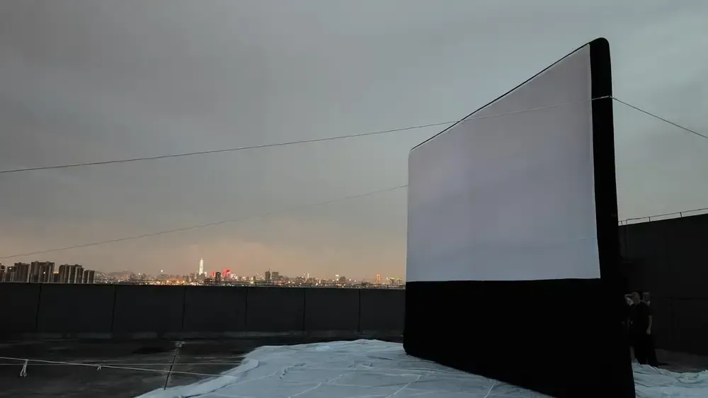 Écran de cinéma gonflable de nuit sur toit d'immeuble