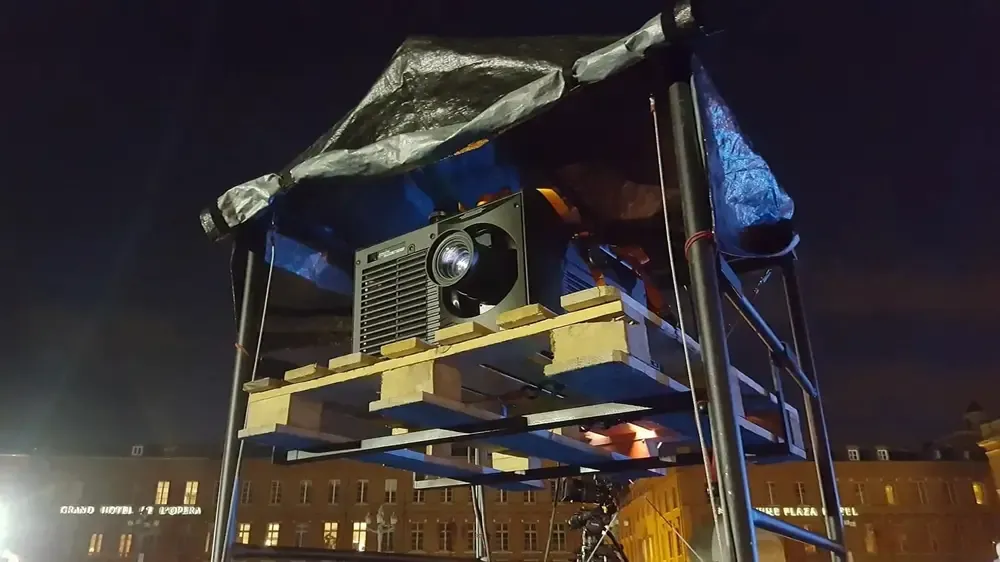 Séance de cinéma drive-in avec voitures devant un grand écran gonflable