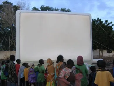 Public rassemblé devant un écran de cinéma gonflable Hallucine à Djibouti, juste avant le début de la séance