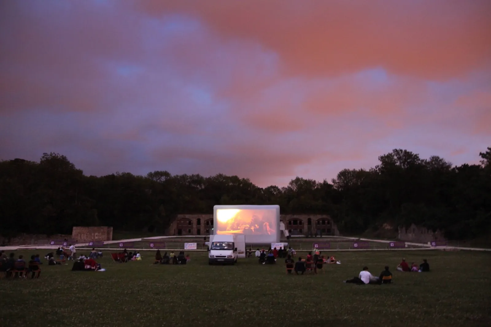 Séance de cinéma en plein air sur écran gonflable Hallucine au coucher du soleil