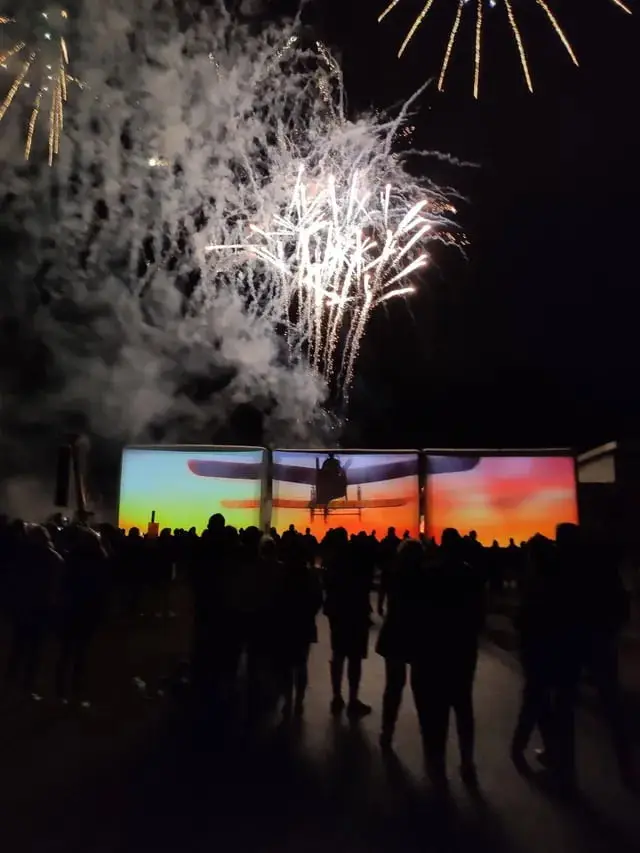 Spectacle nocturne avec trois écrans géants gonflables et feu d'artifice en arrière-plan